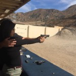 Person aiming a pistol downrange