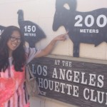 Woman posing by a sign of a goat